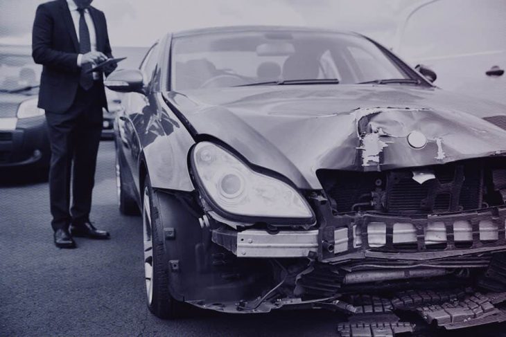 Kuvassa mies ja hajonnut auto